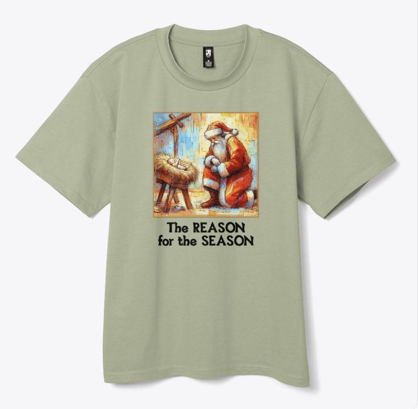 Green Tee with Santa kneeling at the manger of Baby Jesus with the caption The Reason for the Season